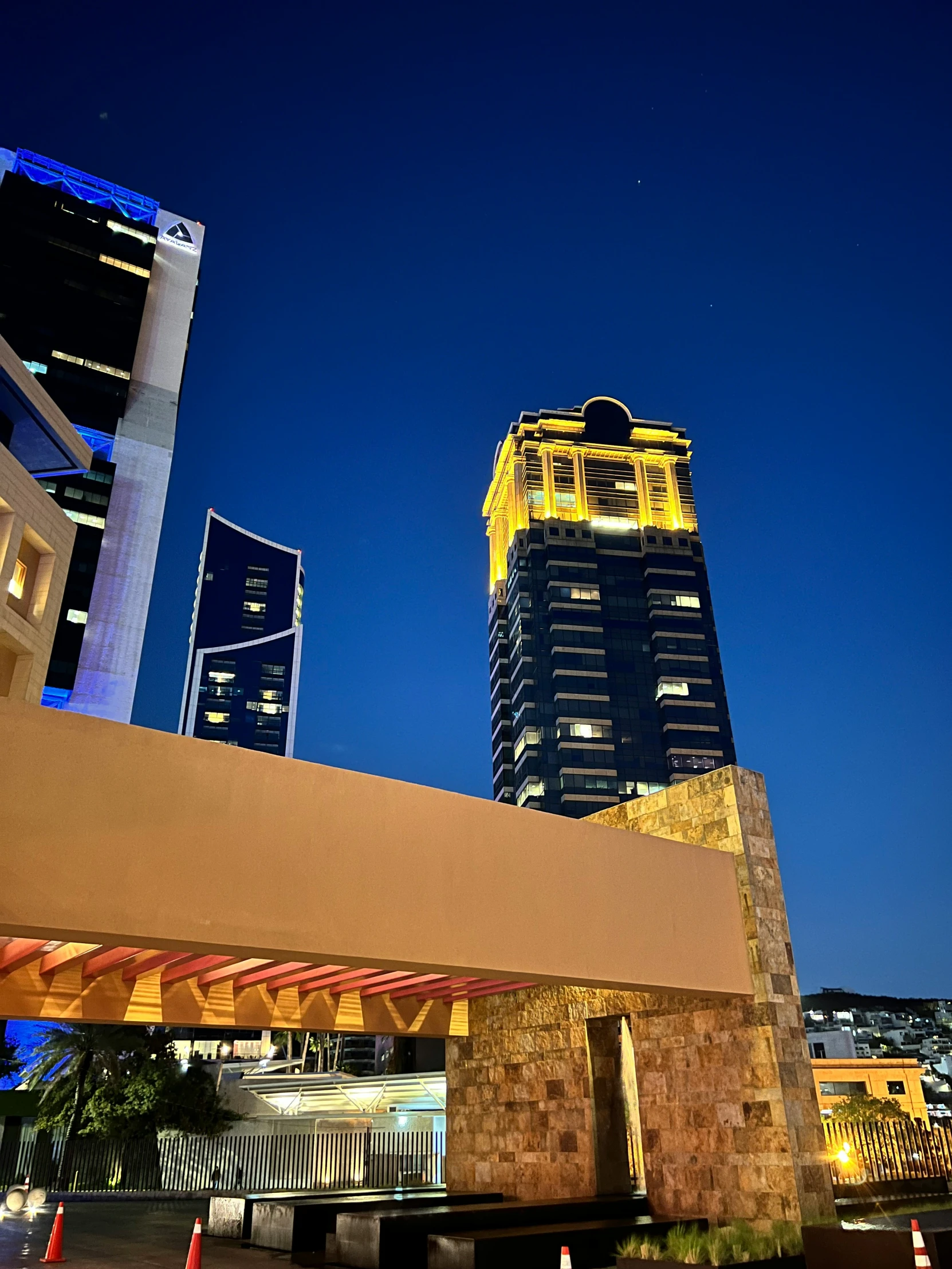 an overhang with street lights and a tall building in the background