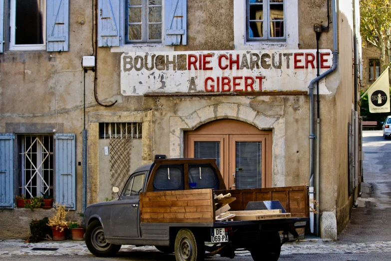 a brown truck parked outside a building with old signage on the side of the building