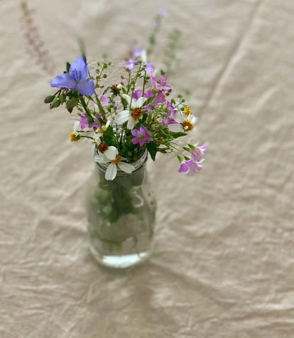 a vase of flowers on a table with paper