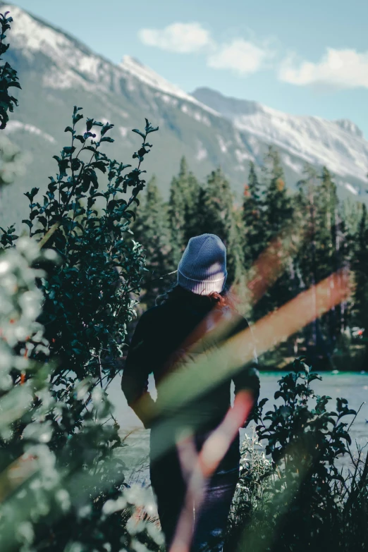 man in the wilderness, view from the trees to the water