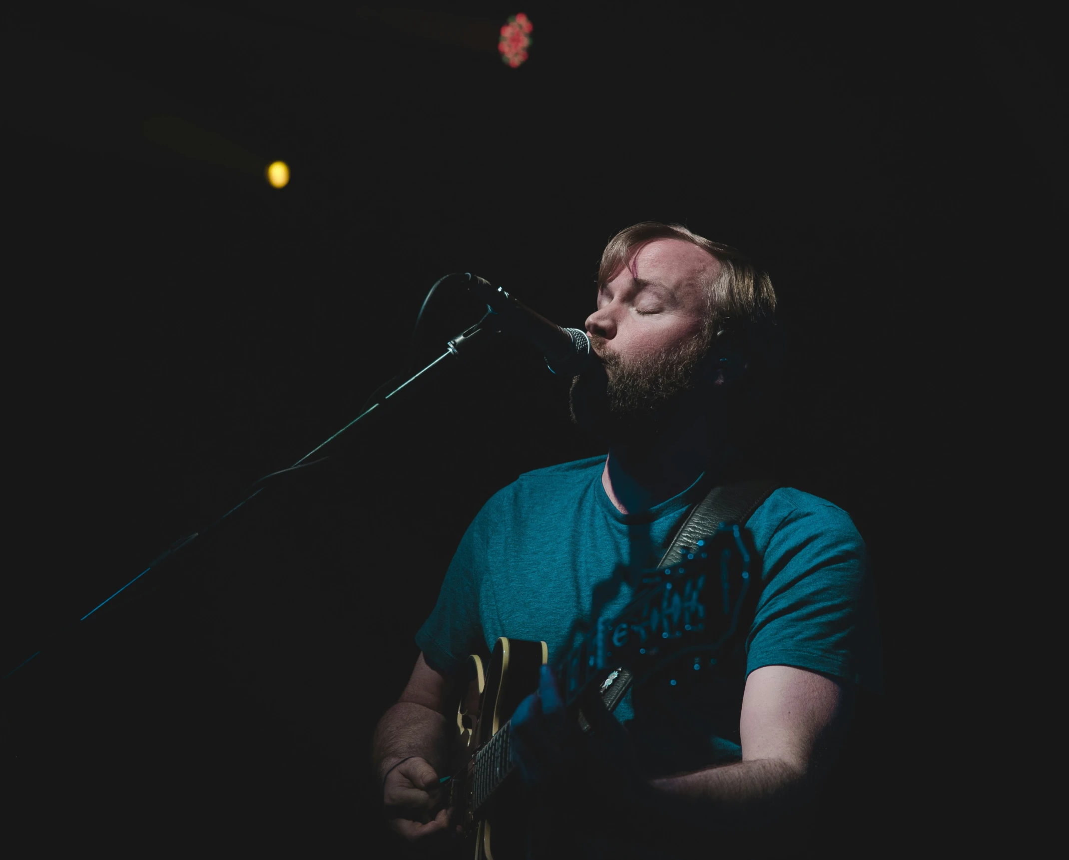 the man is singing and playing his guitar