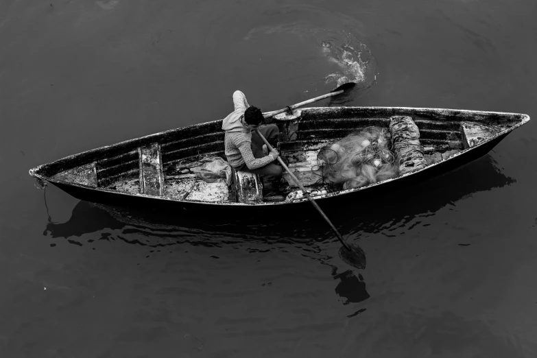 a black and white pograph of someone in a boat