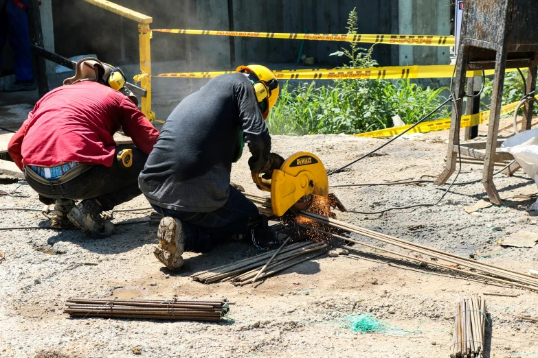 two men working with tools on the ground