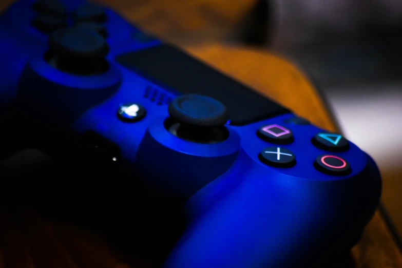 there is a blue video game controller in front of a blurry background
