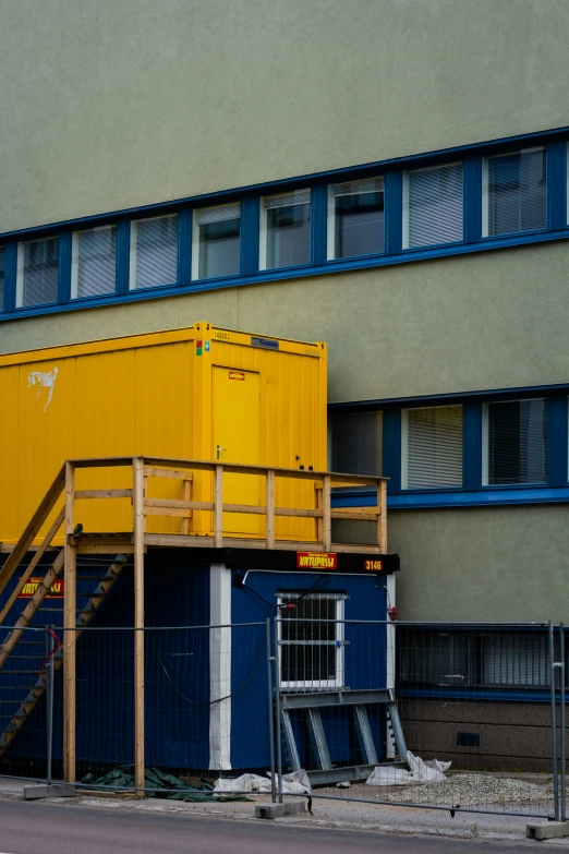 there is a yellow box sitting next to a building