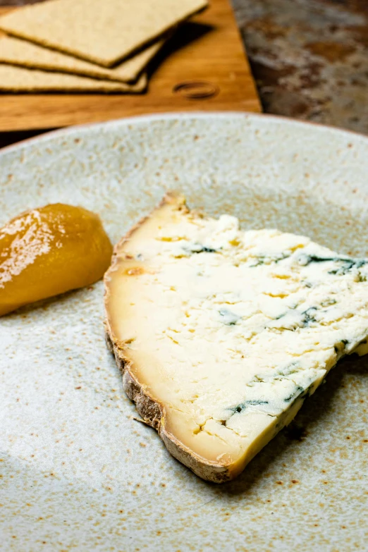 a cheese plate with ers, and a pickle on the side