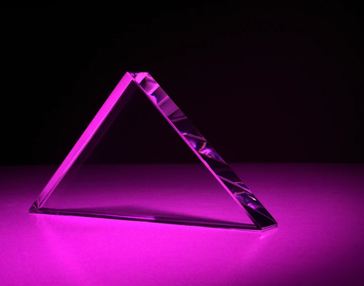 a triangular object with purple light on a dark background