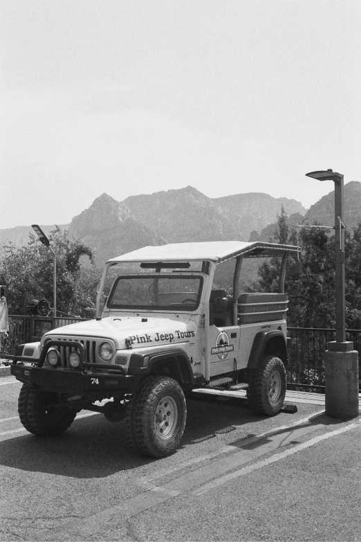 an old military truck parked in front of the side walk of a store