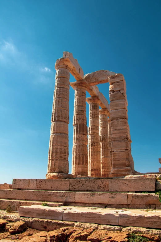 a tall stone structure surrounded by dirt on a sunny day