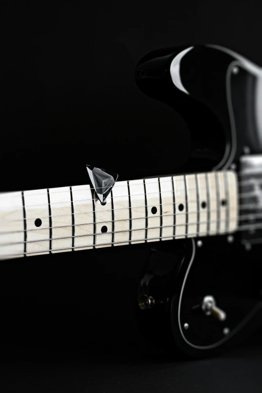 an electric guitar with a black top and white strings