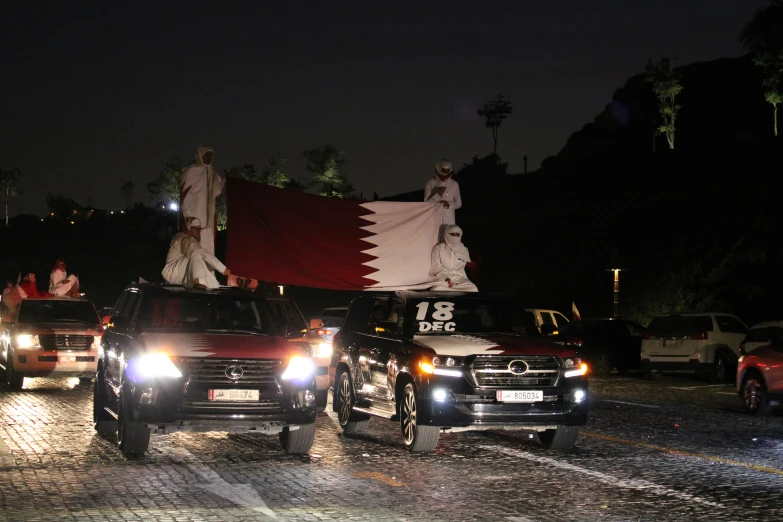 some trucks with a flag on top and three parked in the street