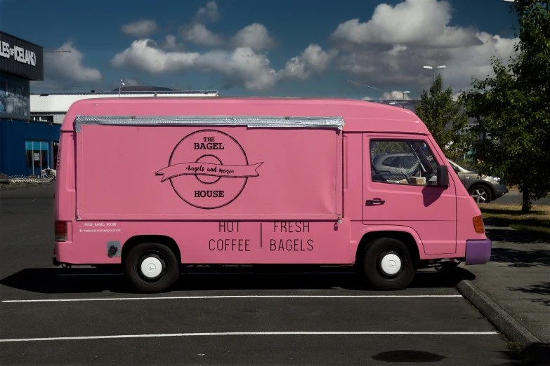 a pink vehicle with stickers on it sitting in a parking lot