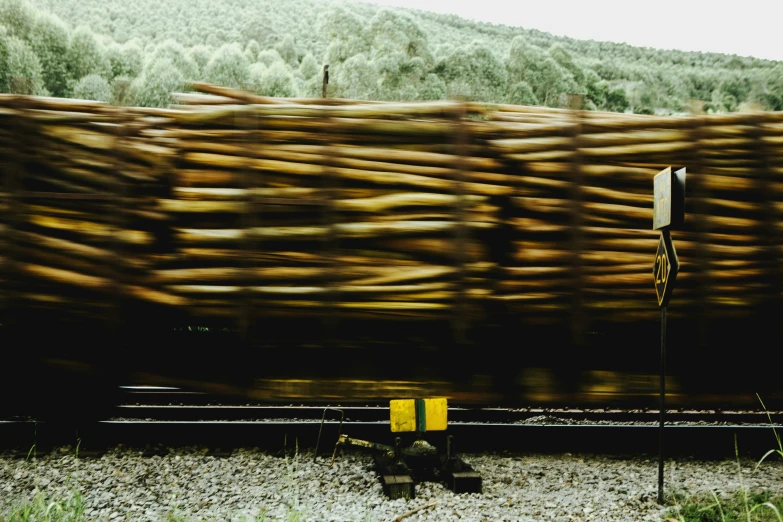 a stack of wood sitting on top of a train tracks