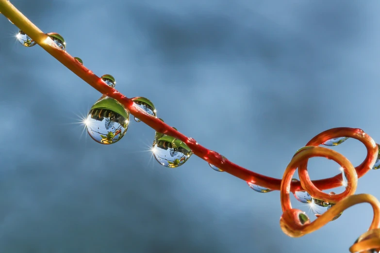 a colorful pipe hanging from the ceiling with water drops