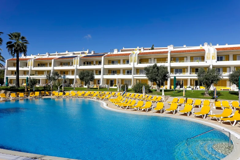 this is a po of a resort pool with yellow chairs