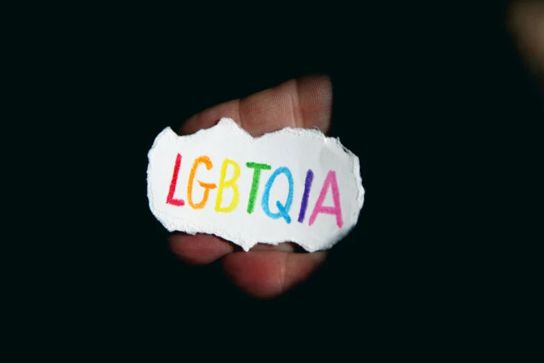 a hand holding a torn piece of paper with the word logttoia written on it