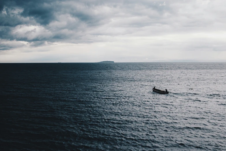 a man in a small boat is out on the open water