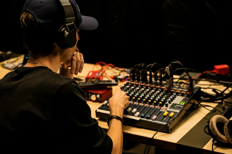 a person sitting in front of sound mixing equipment