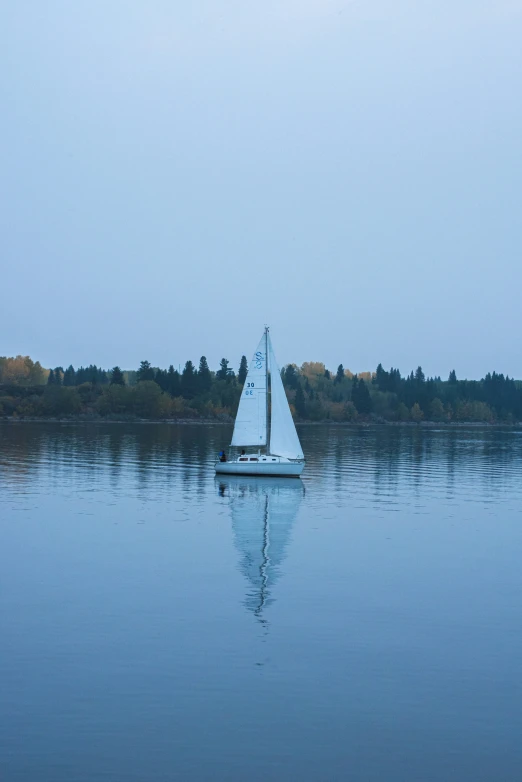 a sail boat sitting on top of a lake