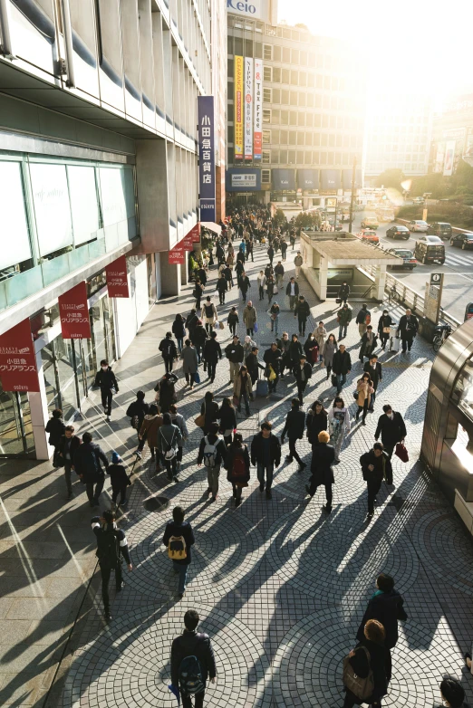 a group of people are walking down a sidewalk