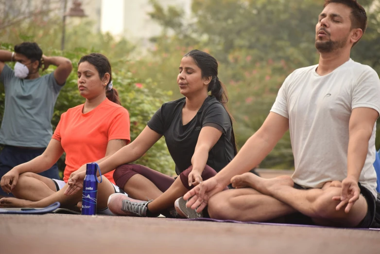 a group of people meditating in the park