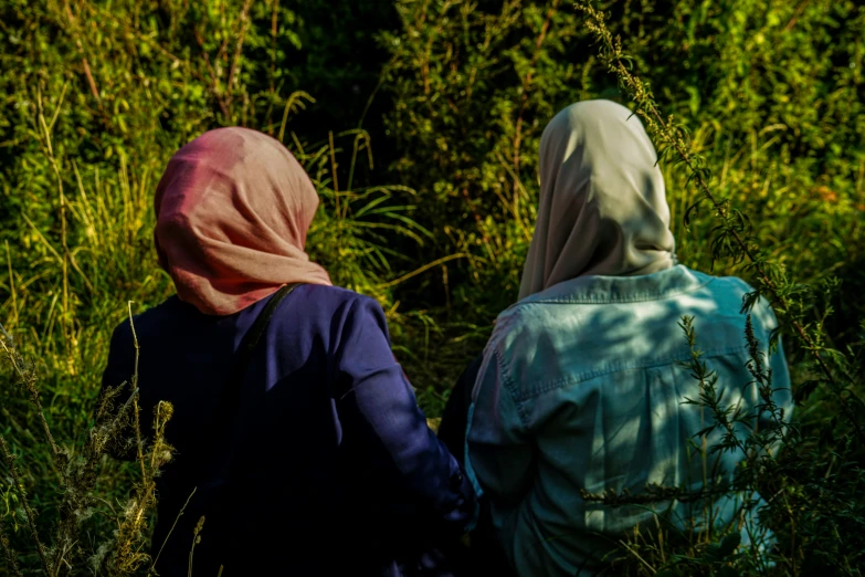 two people standing in front of a forest of tall grass