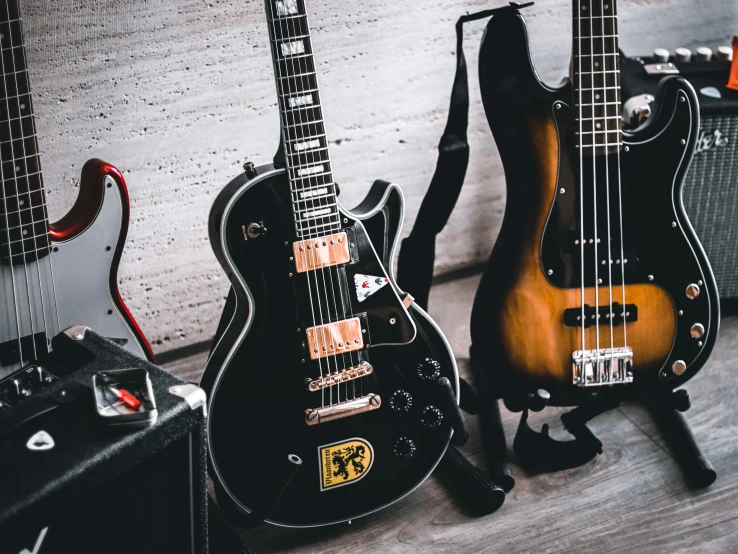 several guitars and amps are sitting on a wooden floor