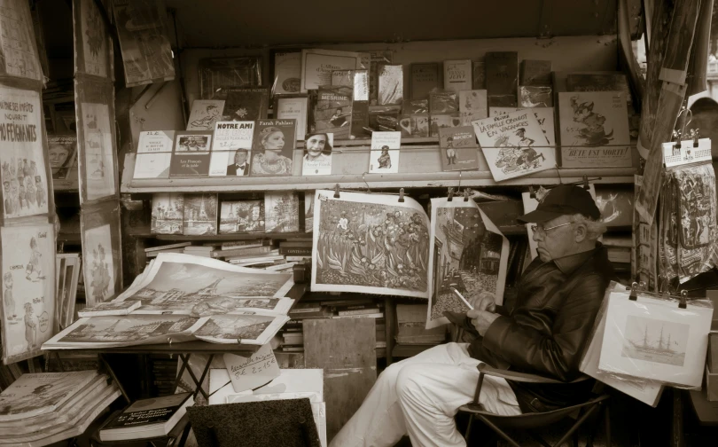 an older man sitting in a chair while looking at books