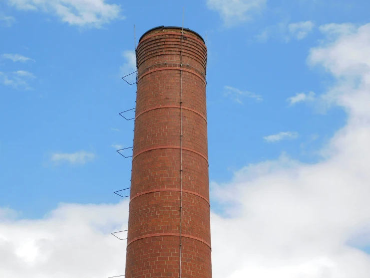 a brick tower with antennas and people around it