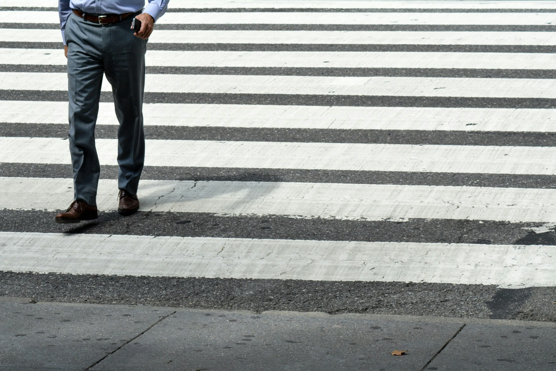 a man with a tie standing in the middle of a crosswalk