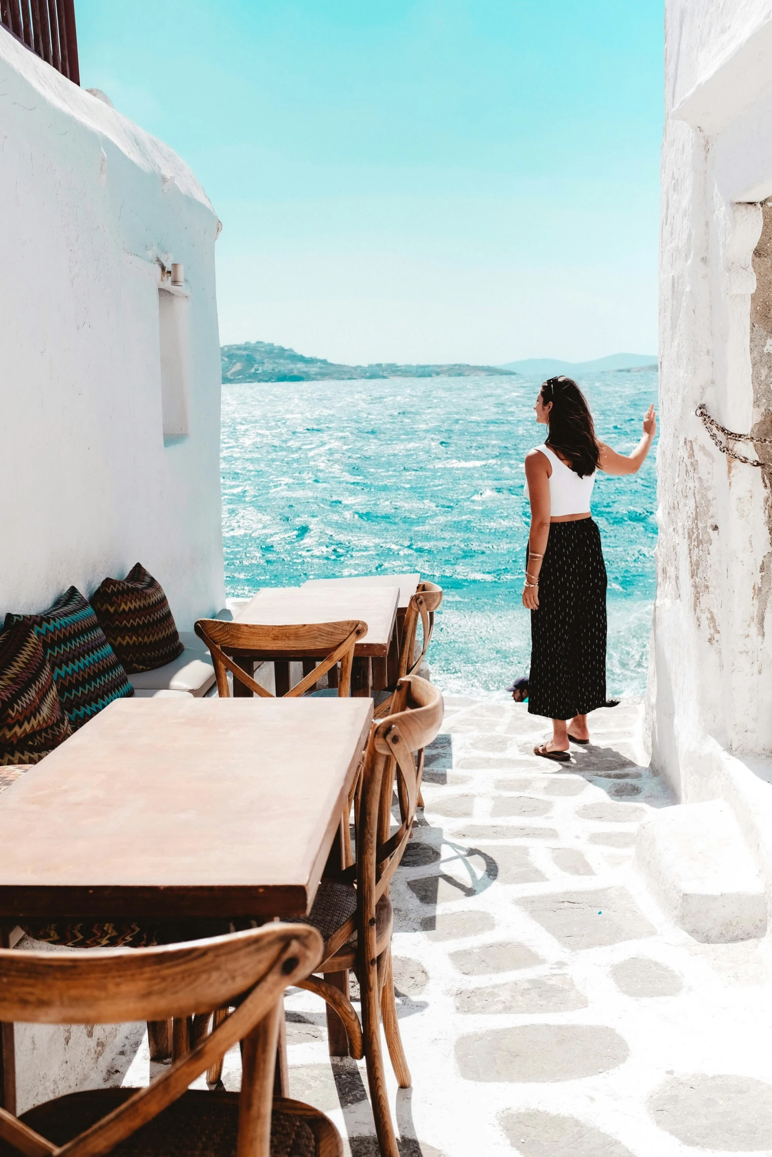 a woman walking down the street near an ocean