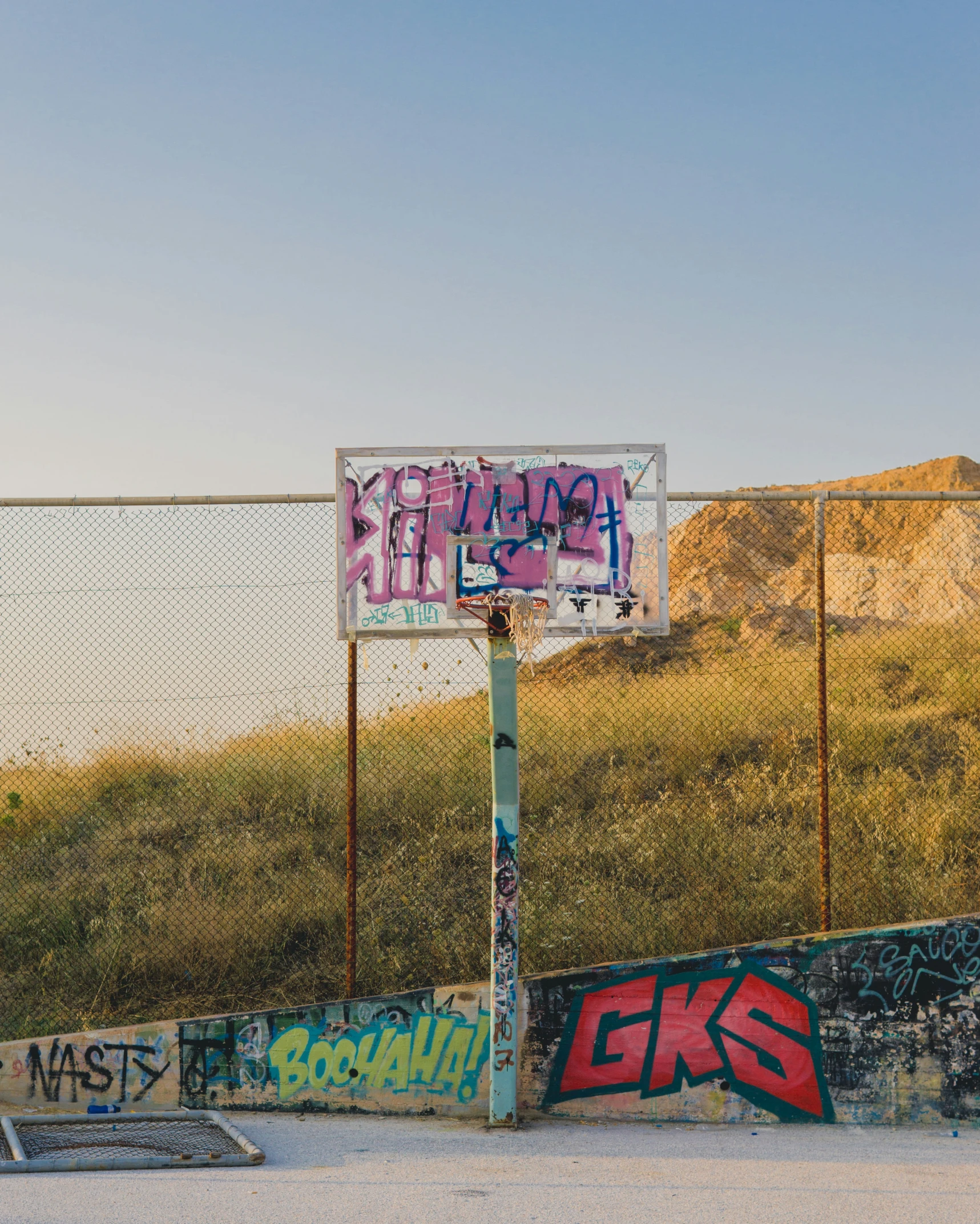 a sign sitting on top of a cement wall near a fence