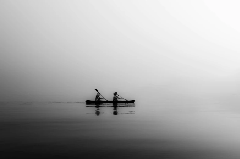 two people on a canoe in the fog
