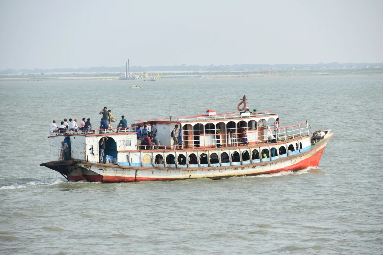 an old fashioned boat with people on board floating in the water