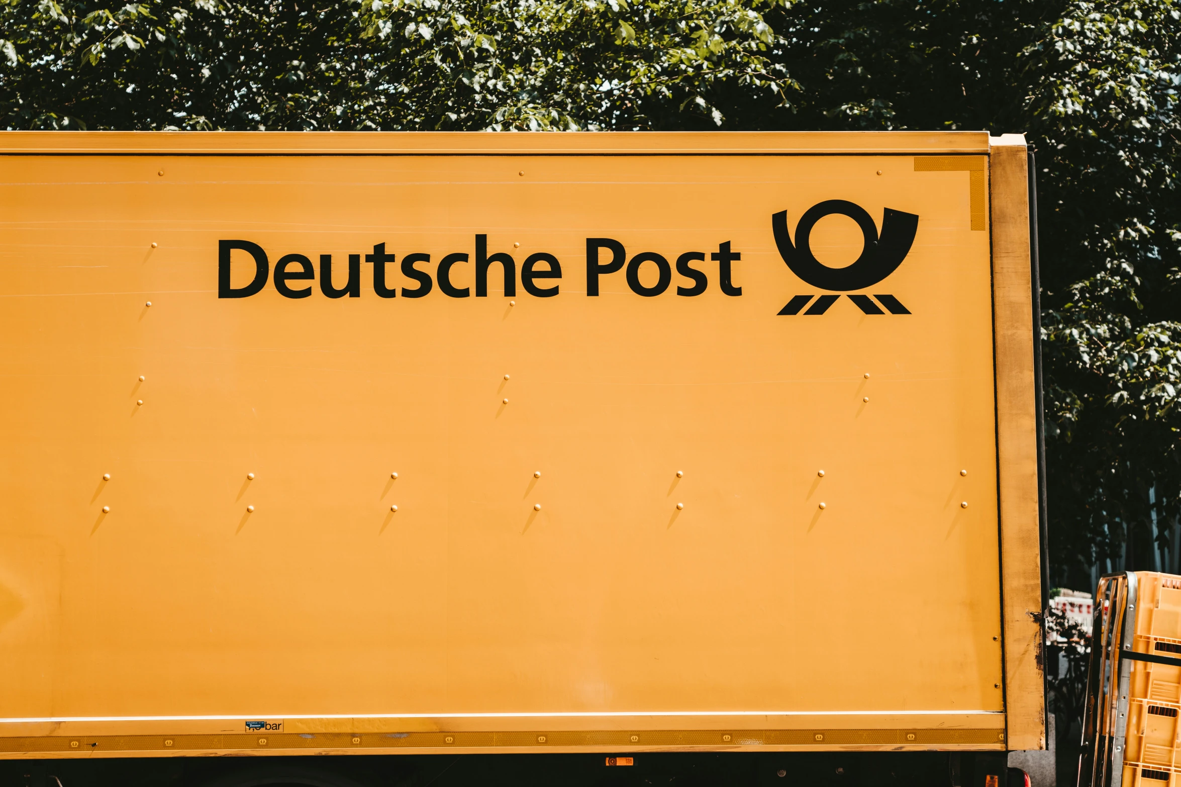 the back end of a yellow truck with german letters