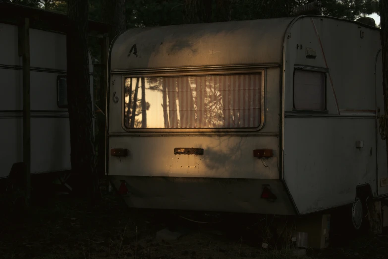 the old rv is parked in the forest at night