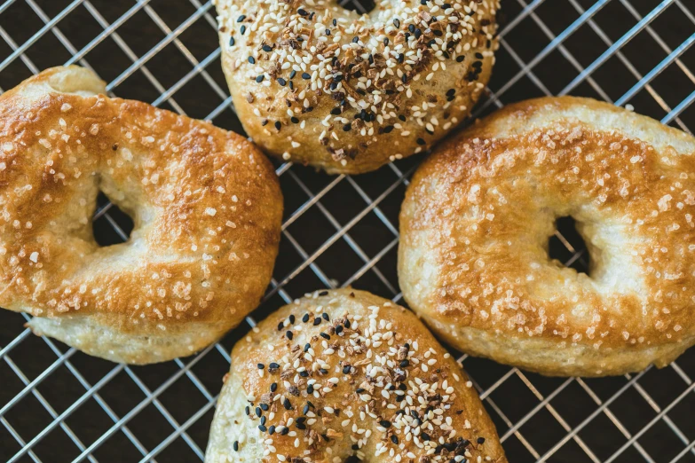 four bagels are sitting on top of a cooling rack