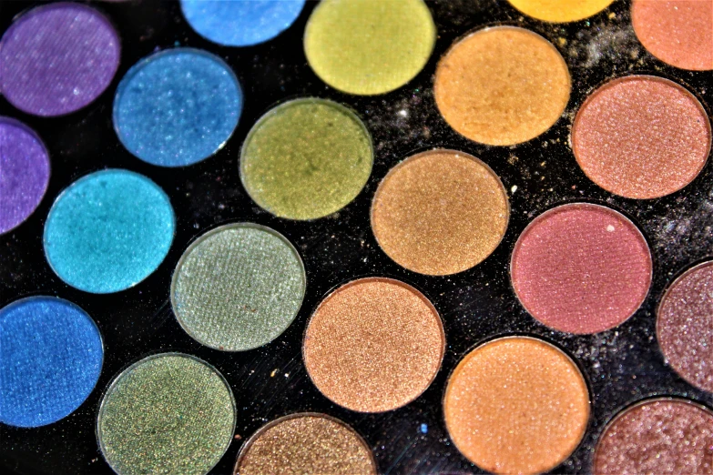 the lids of a colorful, bright eye shadow palette