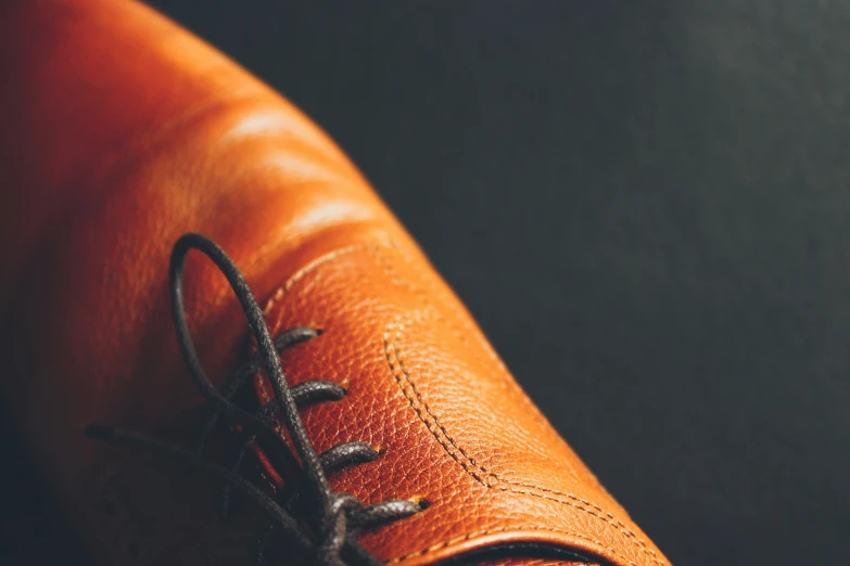 an orange leather device pouch with a small lace