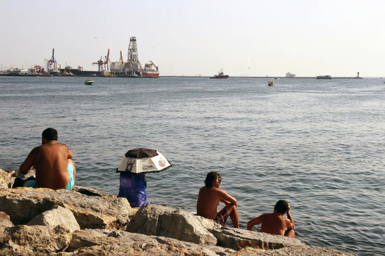 a group of people on a rock next to the water