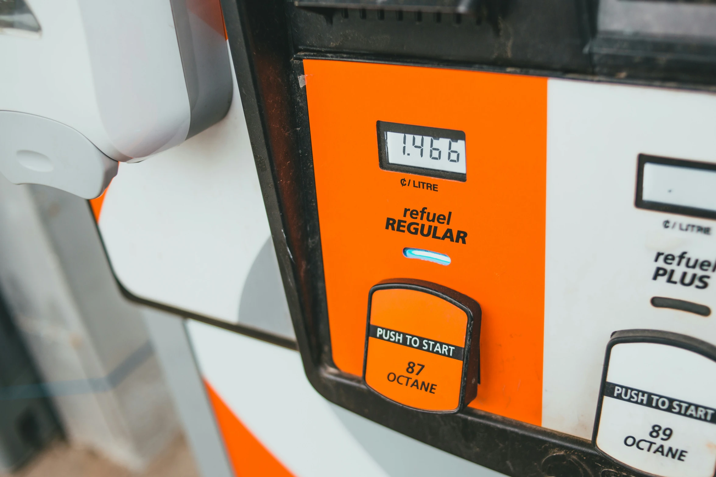 a bright orange gas pump next to another one