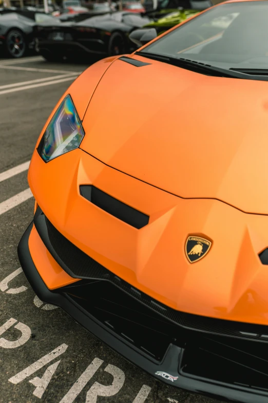 an orange lamb car parked in front of some other cars