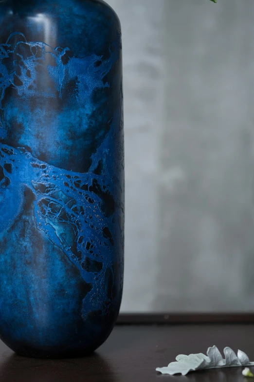 a blue vase has a black marble design on the side