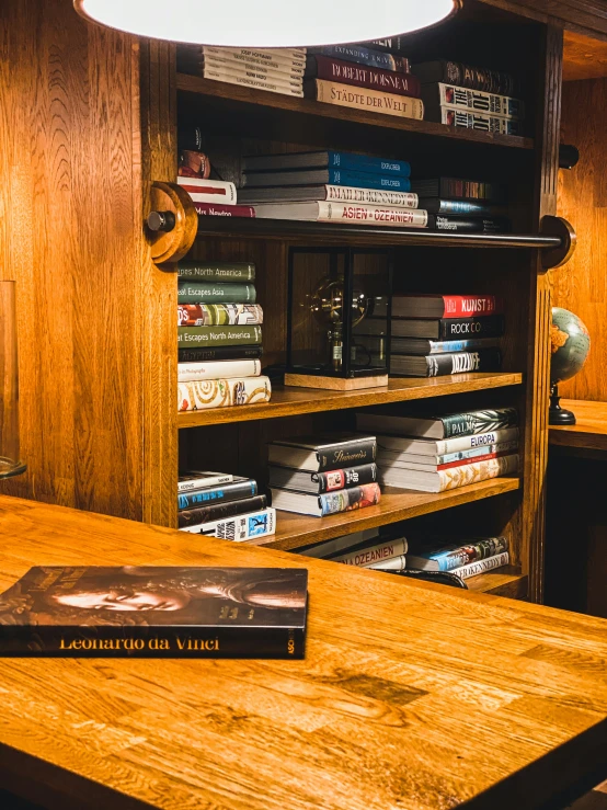 a wooden bookcase filled with books next to a desk