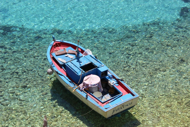 a boat sitting in shallow water on the ocean