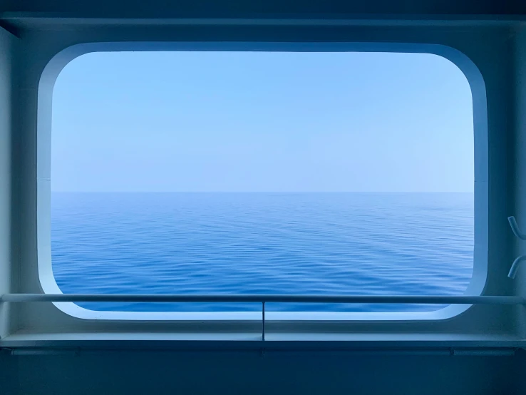 a window looks out at the water from the ocean