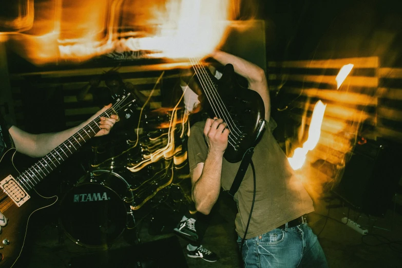 two people playing guitars in a room with sound equipment