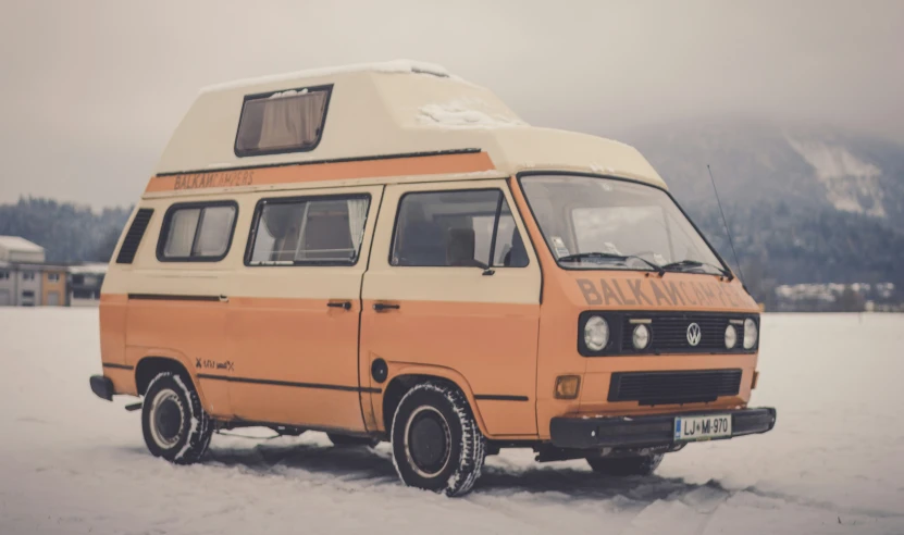 a vintage van is parked in the snow