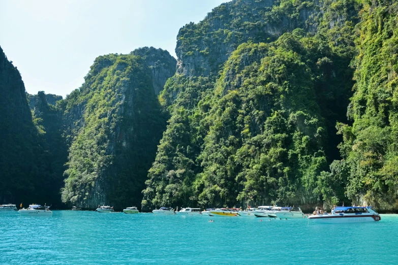 boats are floating on the water near mountain formations