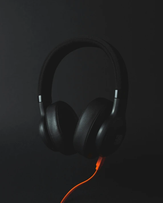 a pair of black headphones resting on a black surface